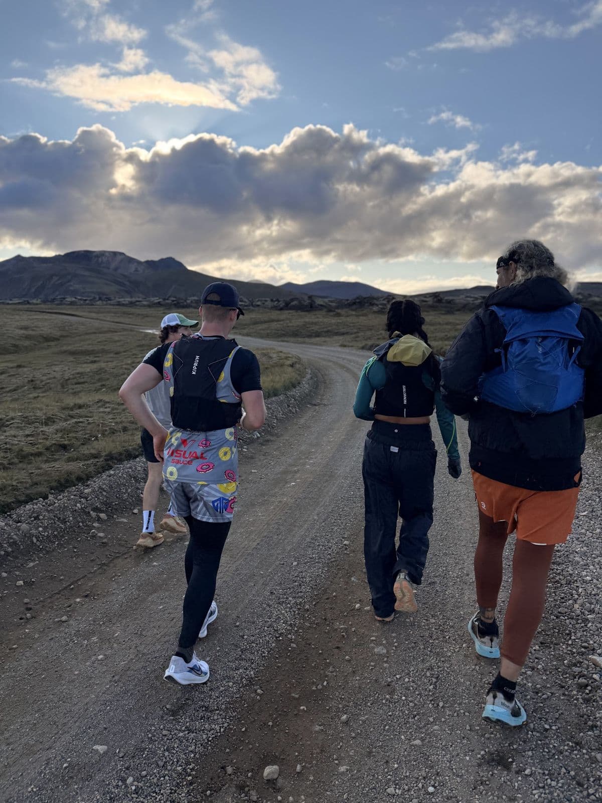 The 2026 crew running a highland road together at golden hour