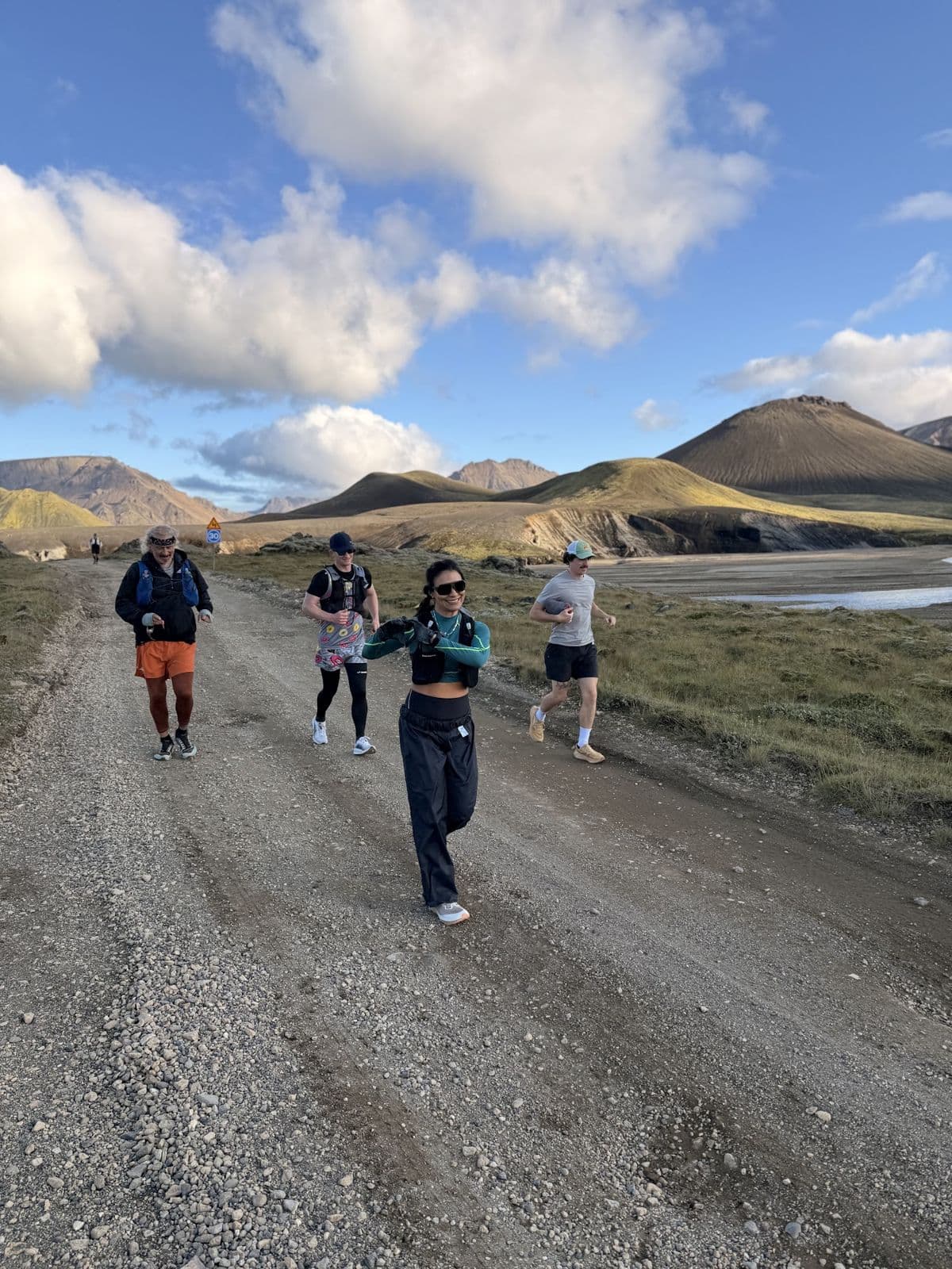 The crew strung out along a road through rhyolite mountains