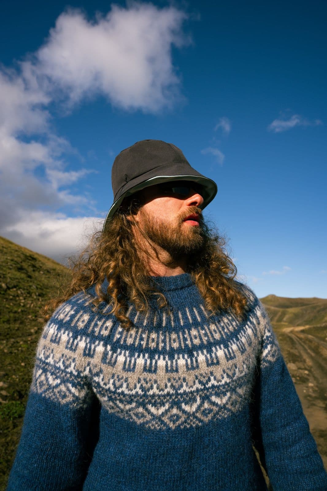 Justin True in an Icelandic wool sweater under a blue highland sky