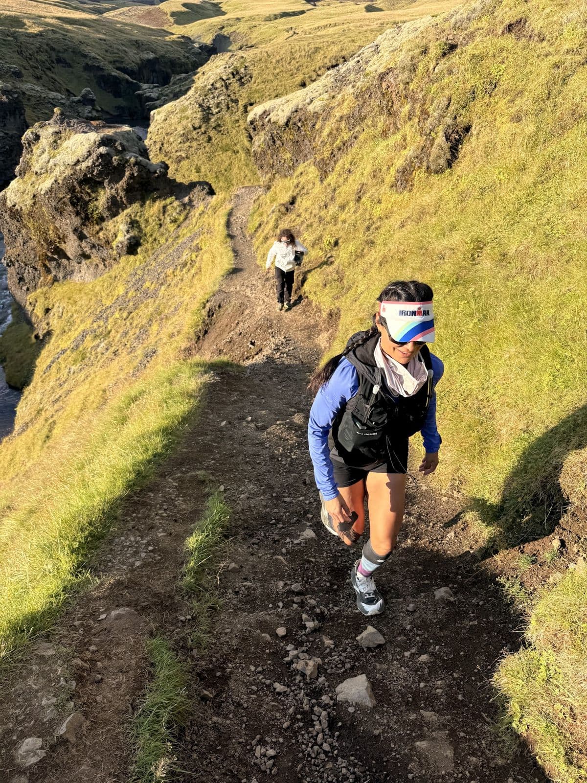 A runner climbing a steep mossy ridge